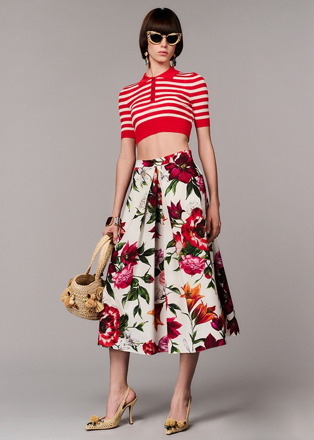 Модель в коллекции Dolce&Gabbana RAFIA FIORI: красная полосатая кофточка и цветочная юбка. На ней солнечные очки и она держит корзинку из рафии.